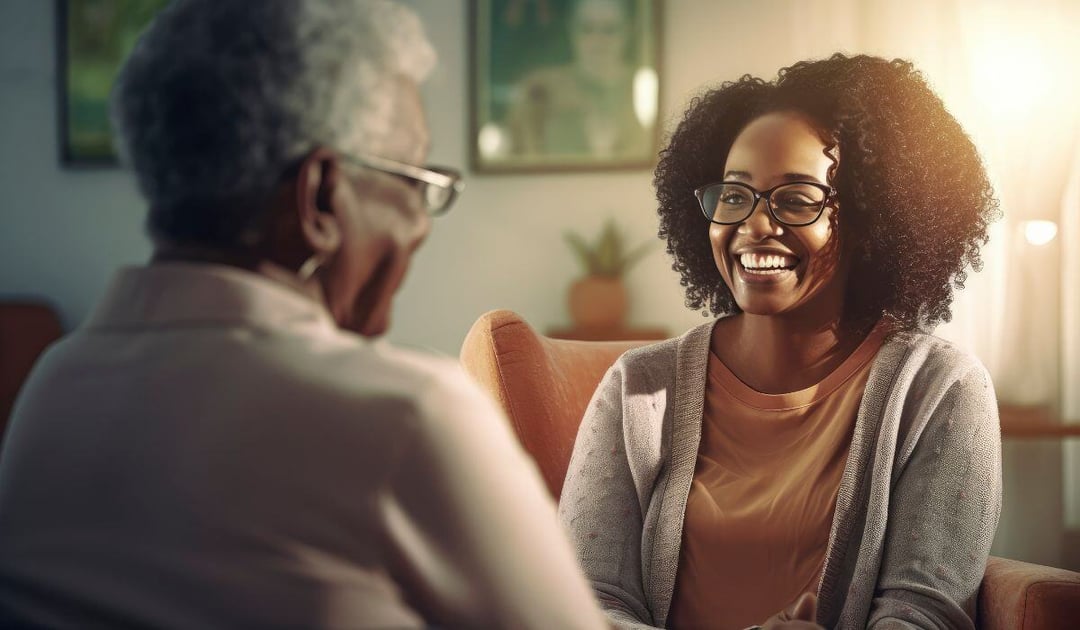 Young black woman talking to older black woman at home