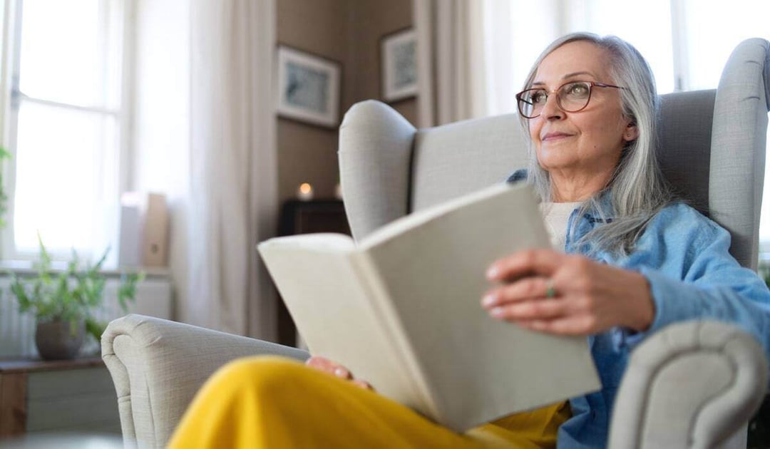 Older woman reading a book at home