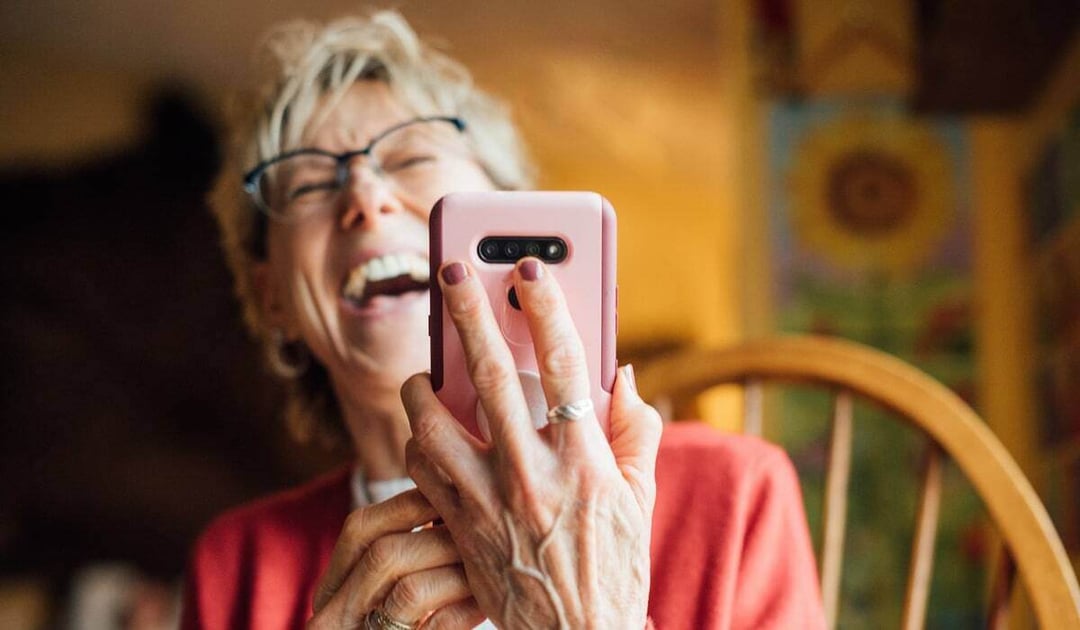 Older woman laughing on a video call on her smartphone