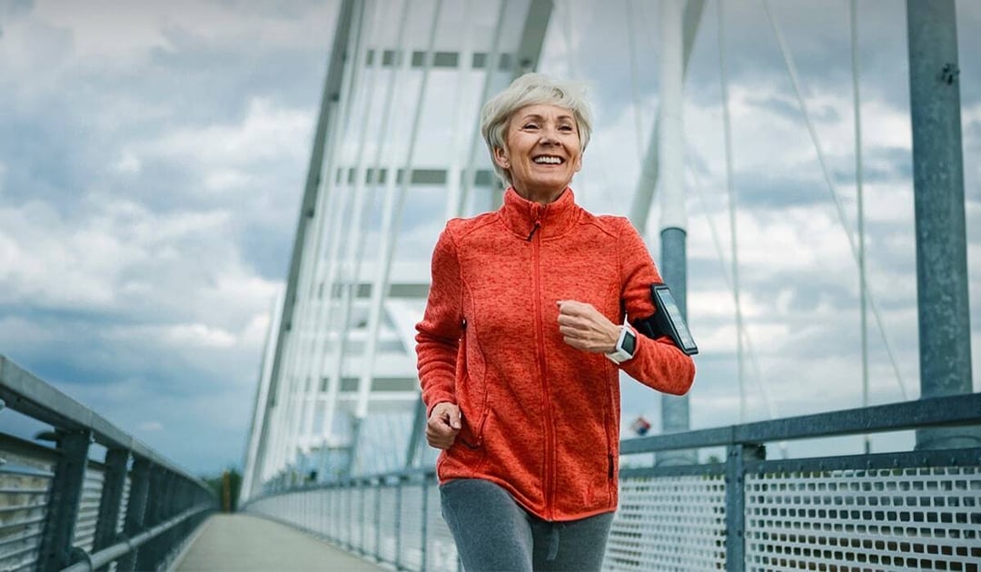 Older woman jogging on a bridge