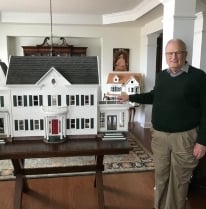 John Herman posing with dollhouse