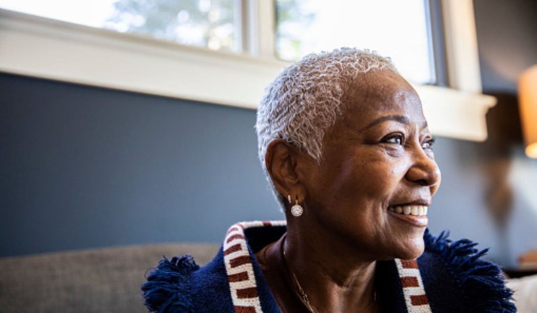 Older black woman sitting at home on her sofa