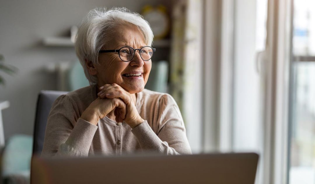 Senior woman sitting with her laptop at home