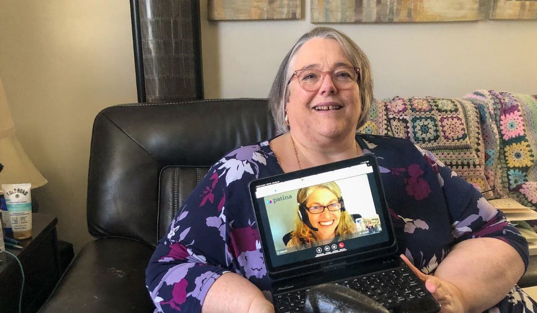 Patina patient Patricia Early in her home with her PCP, Kathy Hill, featured on her iPad screen