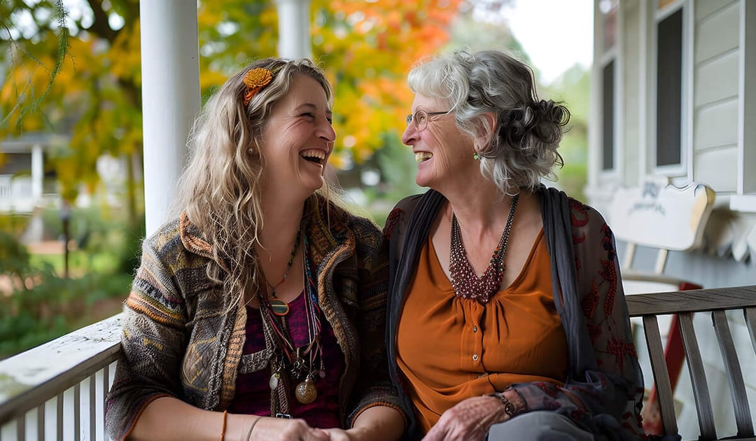 Adult daughter and mother sitting on porch on an autumn day