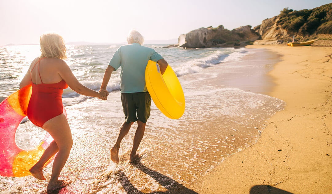 Old couple running on the beach