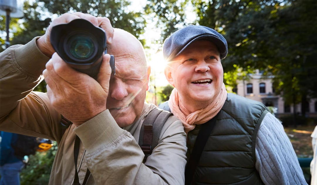 Two white men outside taking photos