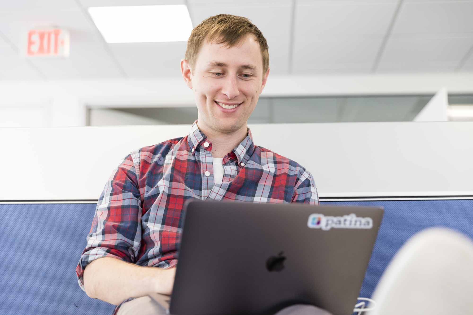 A man smiling down at his open laptop